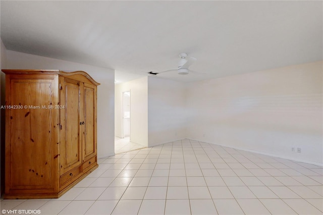 spare room with ceiling fan, lofted ceiling, and light tile patterned floors