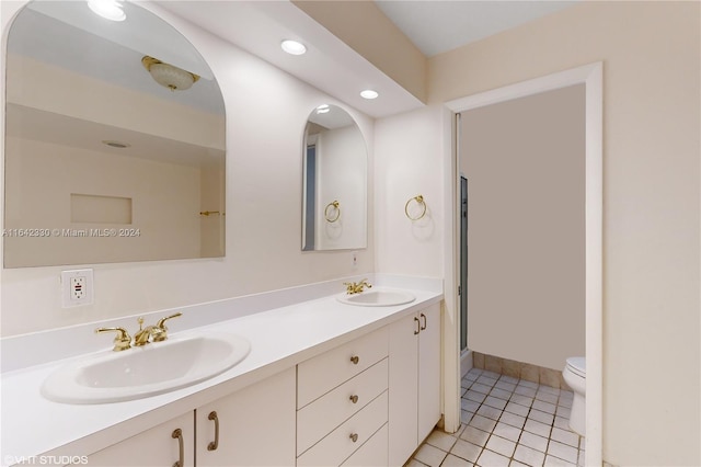 full bath featuring double vanity, tile patterned flooring, a sink, and toilet