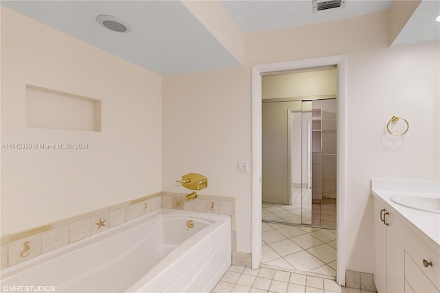 bathroom with tile patterned flooring, a tub to relax in, and vanity