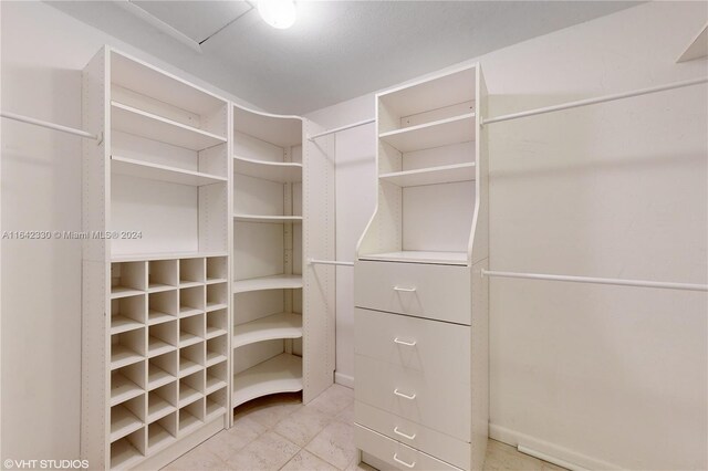 walk in closet with light tile patterned floors