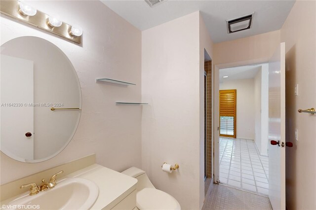 bathroom featuring toilet, tile patterned floors, and vanity