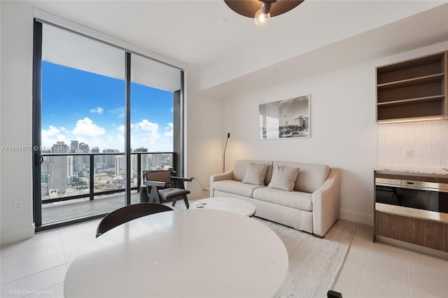 living room with ceiling fan, floor to ceiling windows, and light tile patterned floors