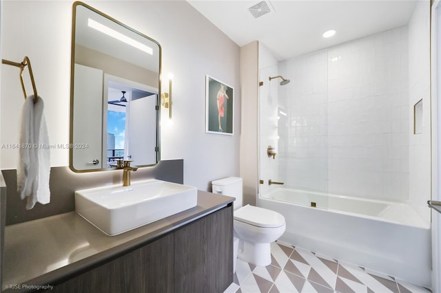 full bathroom featuring vanity, tiled shower / bath, and toilet