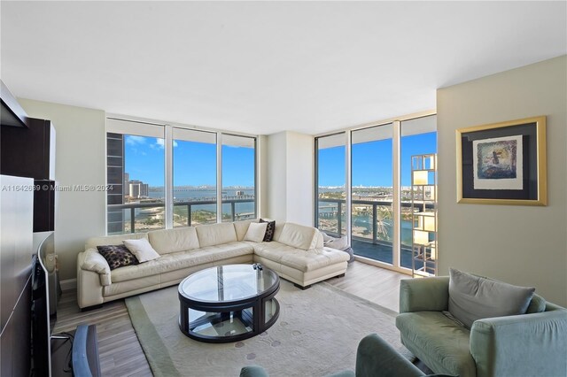 living room featuring a water view, wood-type flooring, and expansive windows