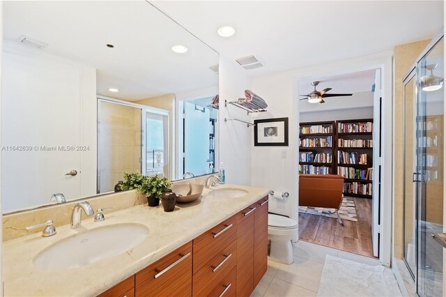 bathroom featuring vanity, an enclosed shower, hardwood / wood-style floors, toilet, and ceiling fan