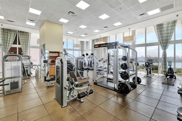 gym with a drop ceiling and a wall of windows