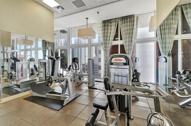 workout area featuring a wall of windows and a towering ceiling