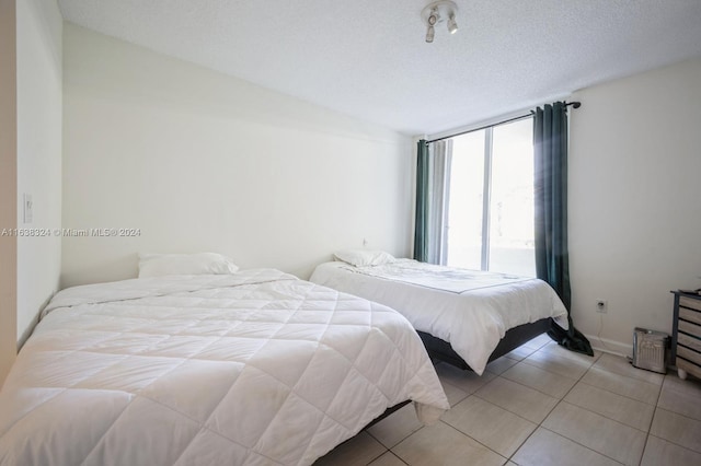 bedroom featuring a textured ceiling and light tile patterned floors