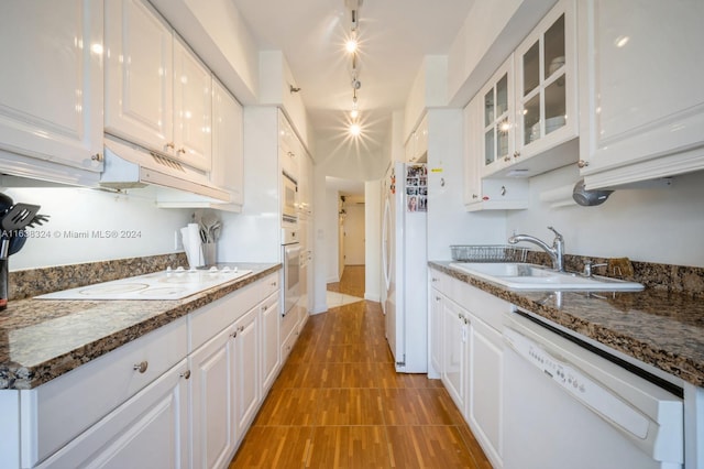 kitchen featuring white cabinets, dark stone counters, sink, and white appliances