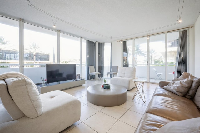 tiled living room featuring a textured ceiling and a wall of windows