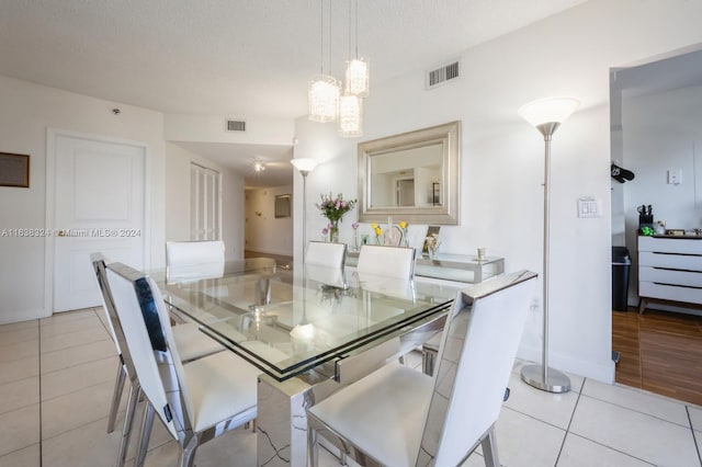 dining space featuring a textured ceiling and light wood-type flooring