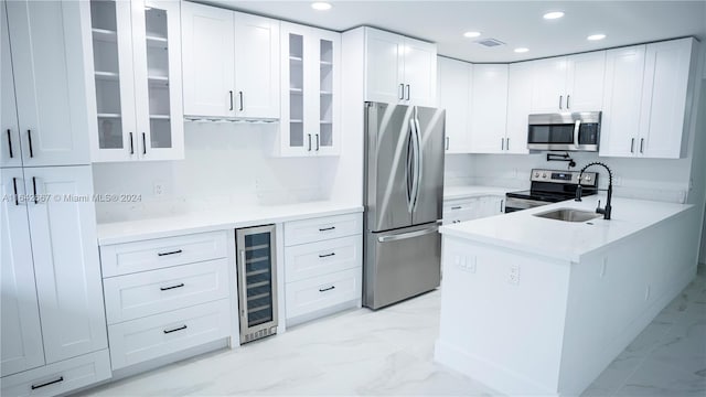 kitchen with stainless steel appliances, white cabinetry, sink, wine cooler, and light tile patterned floors