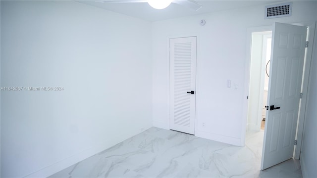 unfurnished bedroom featuring light tile patterned flooring, ceiling fan, and a closet