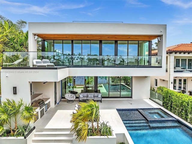 rear view of house featuring a patio and a balcony