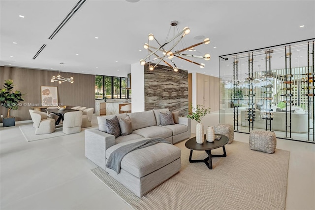 living room featuring concrete flooring and an inviting chandelier