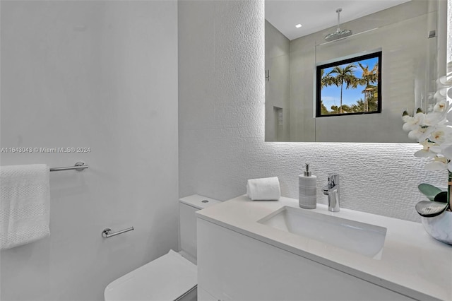 bathroom featuring toilet, tasteful backsplash, and vanity