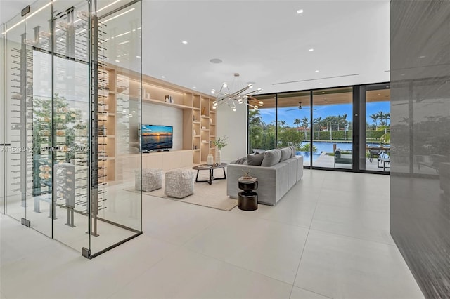 living room with a wall of windows, tile patterned floors, and an inviting chandelier