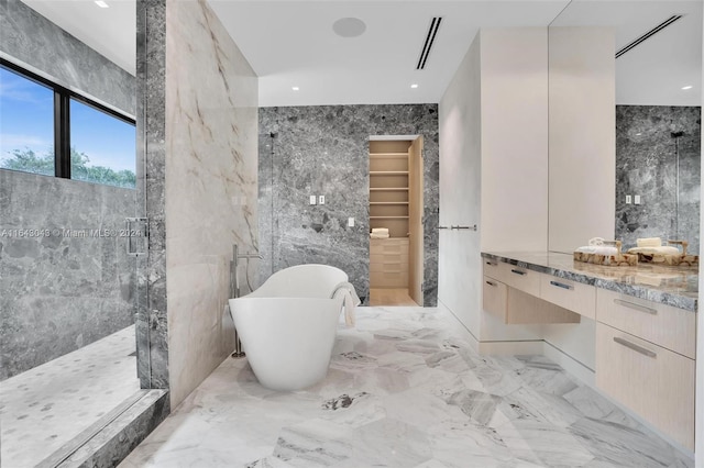 bathroom with independent shower and bath, vanity, and tile walls