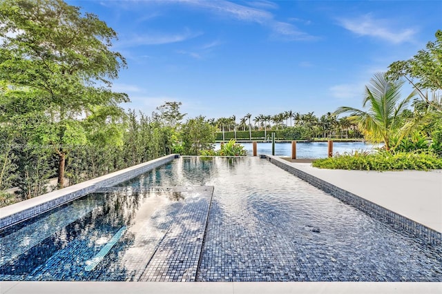 view of swimming pool featuring a water view