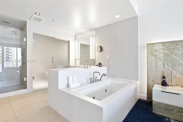 bathroom with tile patterned floors, a tile shower, and vanity