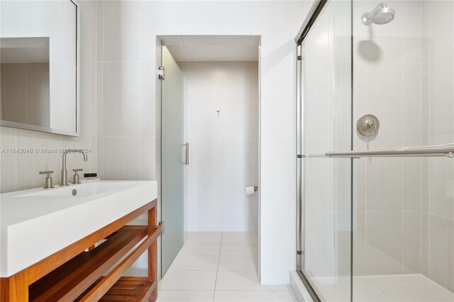 bathroom featuring tile patterned floors, an enclosed shower, vanity, and tile walls