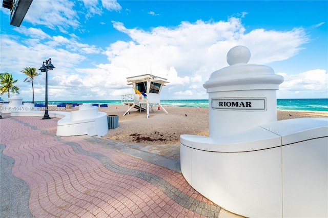 view of property's community featuring a beach view and a water view