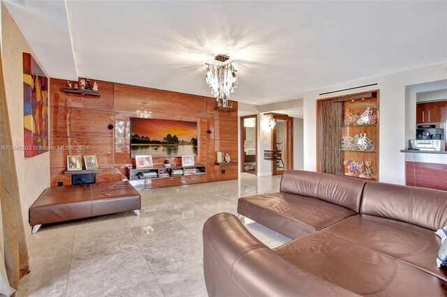 living room featuring wooden walls and a chandelier