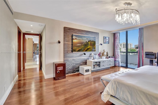 bedroom featuring access to exterior, a chandelier, and hardwood / wood-style flooring