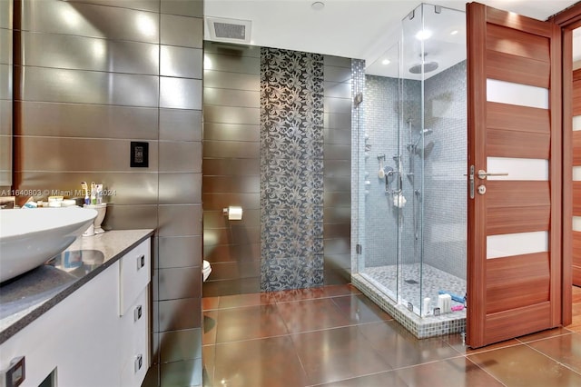 19667 Turnberry Way Unit 3E, Aventura, FL 33180 - bathroom featuring tile patterned flooring, a shower stall, tile walls, vanity, and visible vents