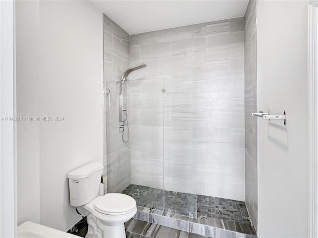 bathroom with a shower with shower door and toilet