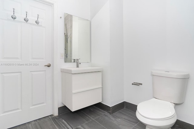 bathroom with tile patterned flooring, toilet, and vanity