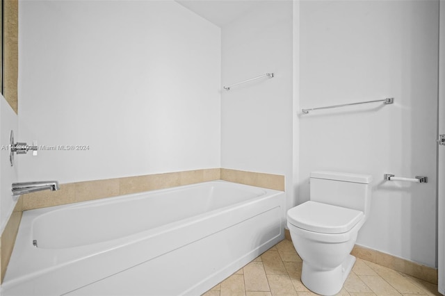 bathroom featuring tile patterned floors, a garden tub, baseboards, and toilet