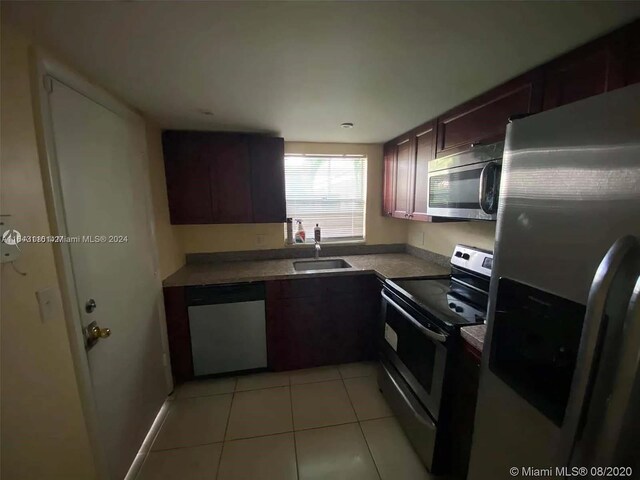 kitchen with sink, appliances with stainless steel finishes, and light tile patterned floors