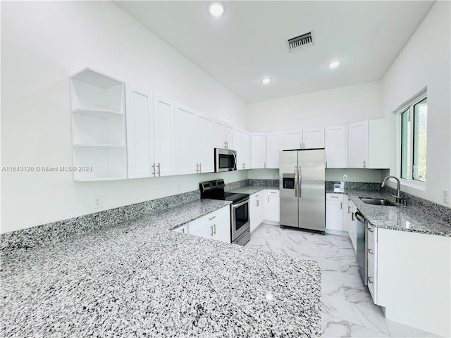 kitchen featuring white cabinets, sink, stainless steel appliances, and dark stone counters