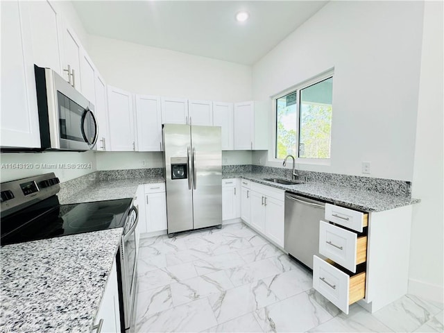 kitchen featuring white cabinets, light stone countertops, sink, and appliances with stainless steel finishes