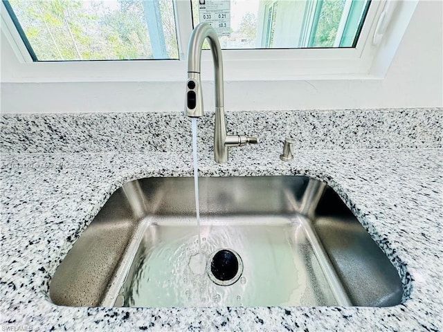 interior details featuring light stone counters and sink