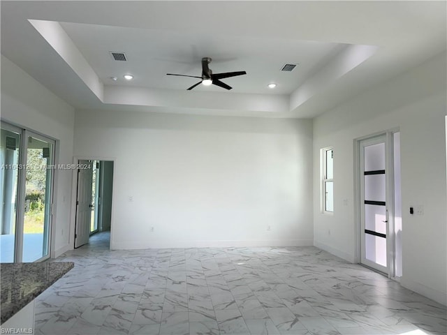 unfurnished room with a raised ceiling and ceiling fan