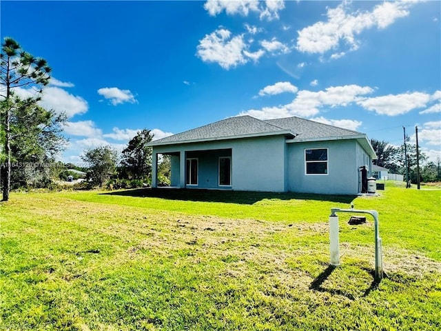 rear view of property with a lawn