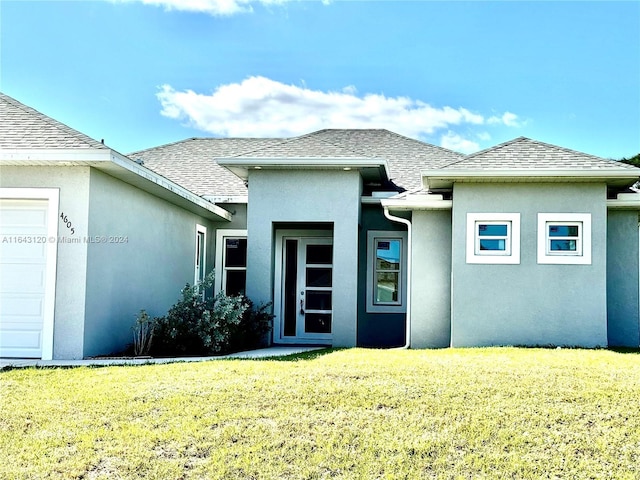 rear view of property with a garage and a yard