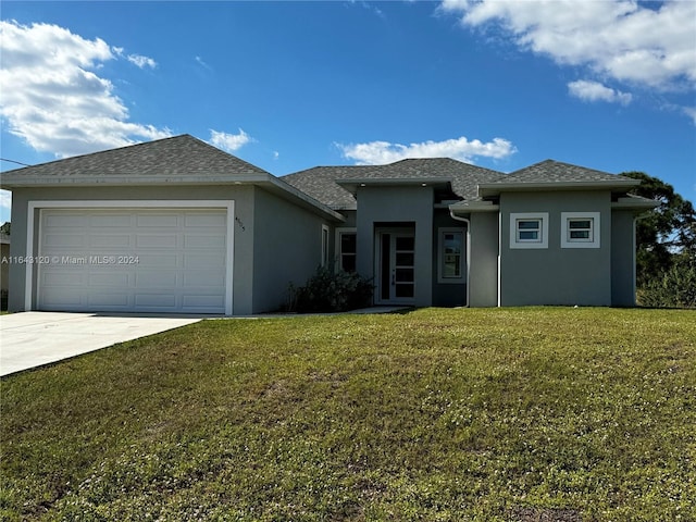 prairie-style house featuring a garage and a front lawn