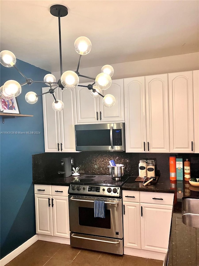 kitchen featuring white cabinets, tasteful backsplash, stainless steel appliances, and dark tile patterned floors