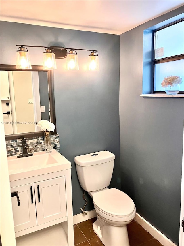 bathroom with toilet, vanity, backsplash, and tile patterned flooring