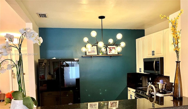 kitchen with white cabinets, hanging light fixtures, and tasteful backsplash