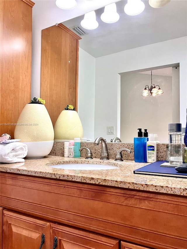 room details featuring vanity and an inviting chandelier