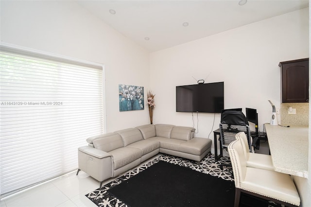 living room featuring light tile patterned floors, vaulted ceiling, and a wealth of natural light