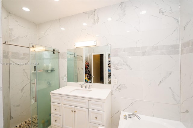 bathroom with separate shower and tub, vanity, and tile walls