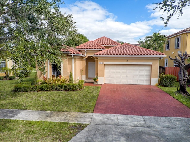 mediterranean / spanish house featuring a garage and a front yard