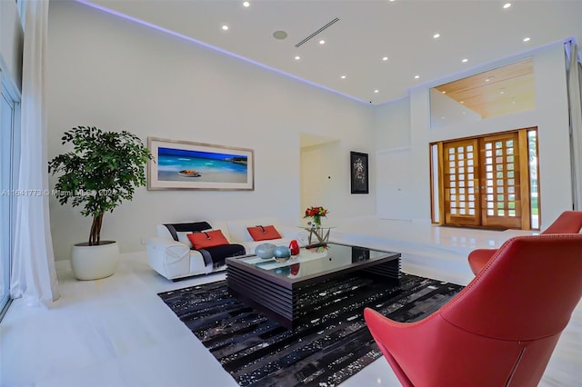 living room with french doors, a towering ceiling, and recessed lighting