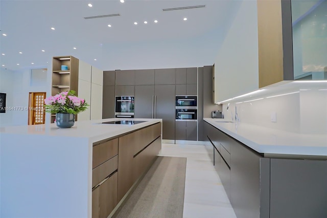 kitchen featuring oven, a sink, light countertops, a large island, and modern cabinets