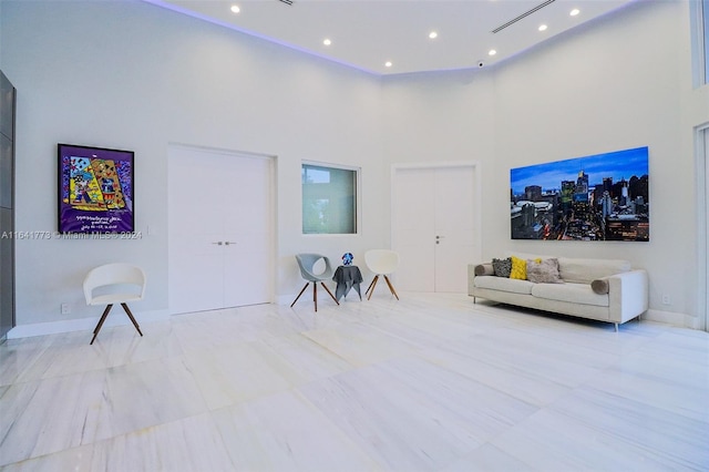 interior space with recessed lighting, baseboards, and a high ceiling